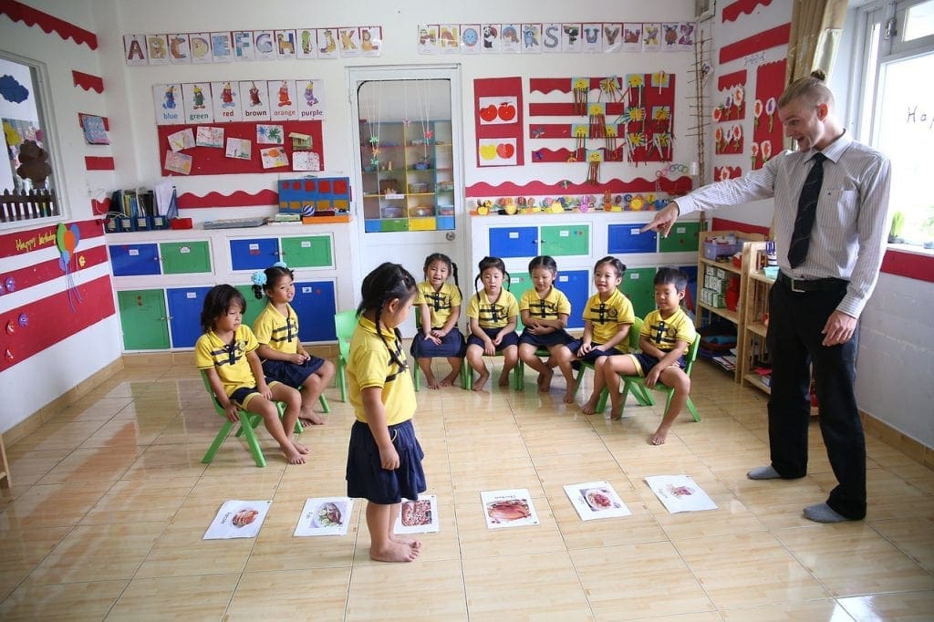 Jobs that let you travel internationally - teacher teaching a room of young students